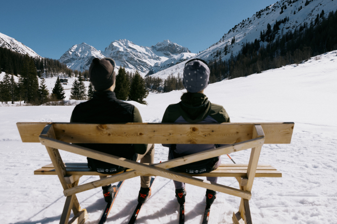 Zwei Langläufer auf einer Bank im Schnee