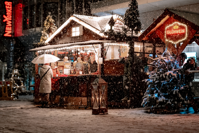 Verschneite Marktstände und Glühweinstand am Christkindlimarkt Chur am Abend