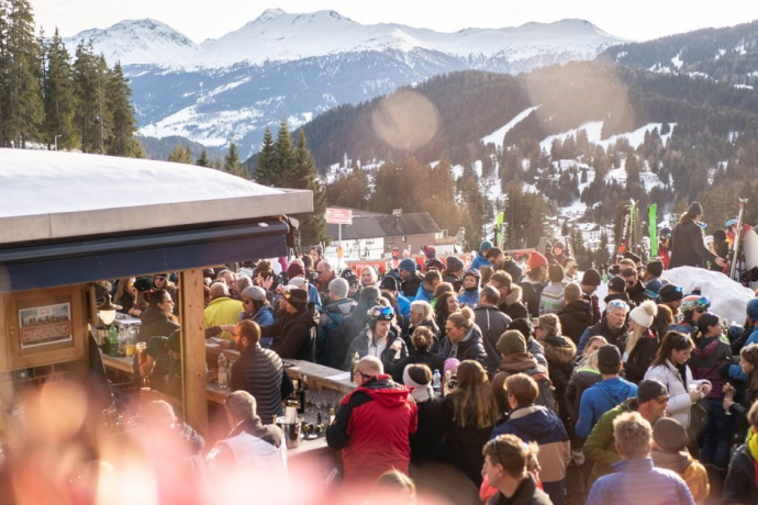 Begeisterte Après-Ski-Fans genissen die Party und die tolle Berglandschaft bei bestem Wetter in der Après-Ski Bar Crest'Ota.