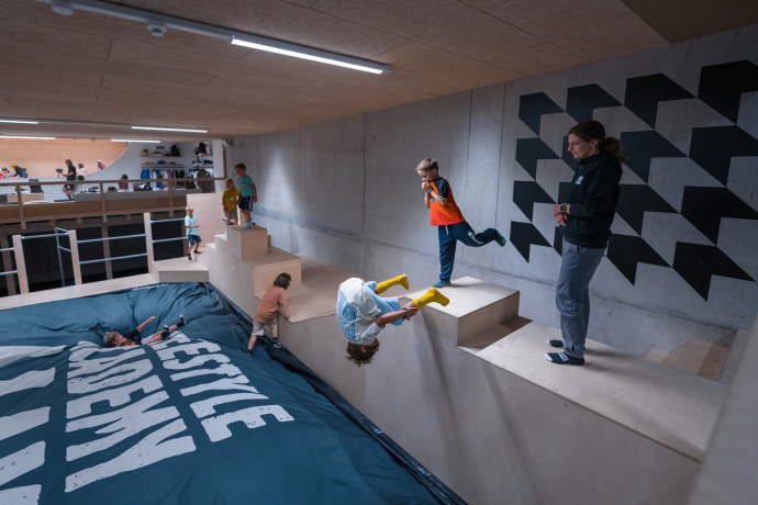 Kinder springen in der Freestyle Academy Laax auf einen grossen Air Bag