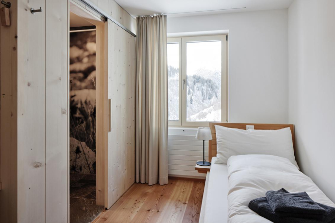 Einzelzimmer im Hotel medelina in Curaglia mit Blick auf verschneite Berghänge in der Surselva