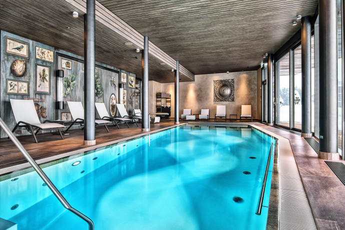 Der Relaxpool mit Liegestühlen im Wellnessbereich des Valsana Hotel Arosa