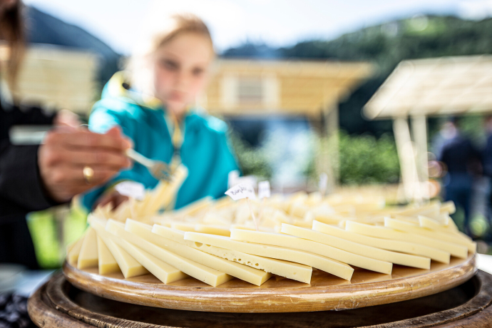 Ein Kind probiert ein Stück Käse von einer Käseplatte