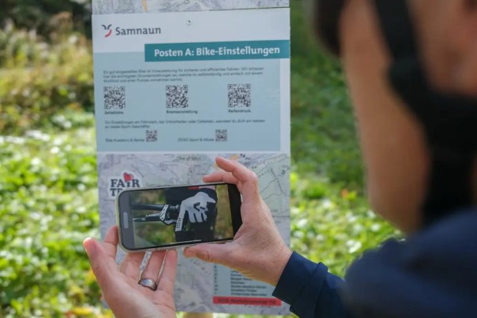 Person schaut sich auf dem Smartphone ein Lernvideo des Skill Loop Samnaun an