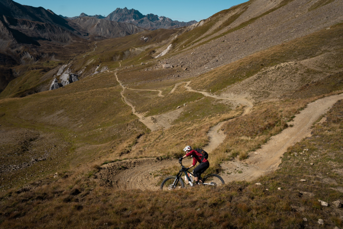 Mountainbiker auf einem schmalen Trail in einer hochalpinen Landschaft