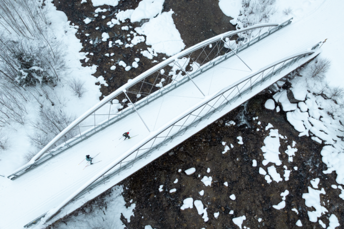 Draufsicht auf zwei Langläufer auf einer Brücke in Disentis