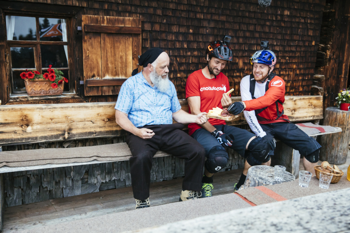 Pause machen bei der Alphütte Fops: Danny MacAskill und Claudio Caluori stärken sich mit einem Bündner-Plättli (Bild: Martin Bissig) Pause machen bei der Alphütte Fops: Danny MacAskill und Claudio Caluori stärken sich mit einem Bündner-Plättli (Bild: Martin Bissig)