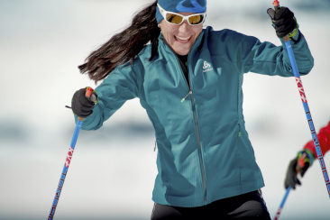 Eine Frau in blauer Jacke beim Langlaufen