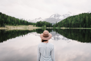 Frau geniesst Aussicht am Stazersee im Oberengadin