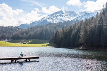 Frau macht Yoga-Übung am Schwarzsee in Davos