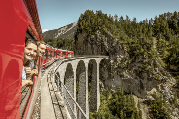 Zwei Personen schauen aus dem Zugfenster auf das Landwasserviadukt