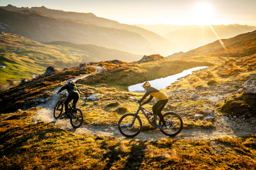 Eine Mountainbikerin und ein Mountainbiker auf einem Trail in der Ferienregion Flims Laax Falera