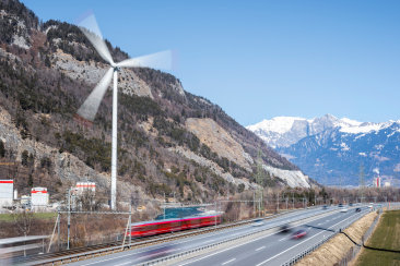 Windrad, Rhätische Bahn und Autobahn in der Umgebung von Chur, die eine nachhaltige Infrastruktur repräsentieren