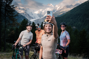 Frauen auf Mountainbikes, eine macht ein Selfie mit ihren Freundinnen vor dem Morteratschgletscher
