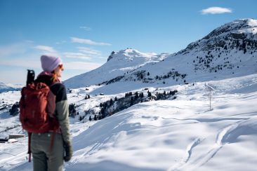 Person auf der Winterweitwanderung Via Mundaun die Aussicht am geniessen