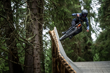 Mountainbiker fährt über ein steiles Northshore-Holzelement mit Airtime auf der SHOREline/STYLEline im Bike Kingdom Park Lenzerheide