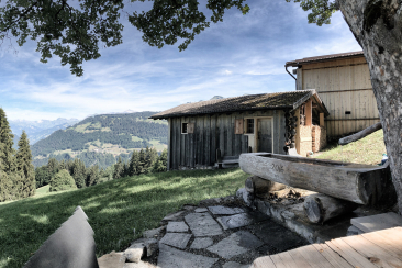 Maiensäss Rameidels in Fideris mit Panoramablick über das Prättigau und Brunnen im Vordergrund