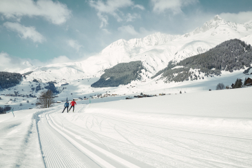 Zwei Langlaufende auf der präparierten Loipe in Disentis Sedrun.