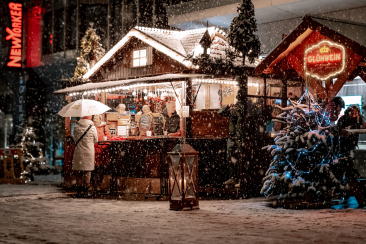 Verschneite Marktstände und Glühweinstand am Christkindlimarkt Chur am Abend