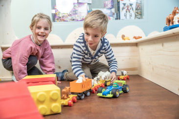Zwei Kinder spielen mit LEGO Duplo und Spielzeugautos im Kids Inn by LEGO im Valbella Resort Lenzerheide
