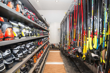 Regale mit Langlaufschuhen und Langlaufstöcken im Sportgeschäft