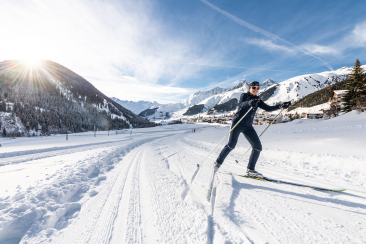Langläuferin umgeben von dem Bergpanorama in Disentis Sedrun
